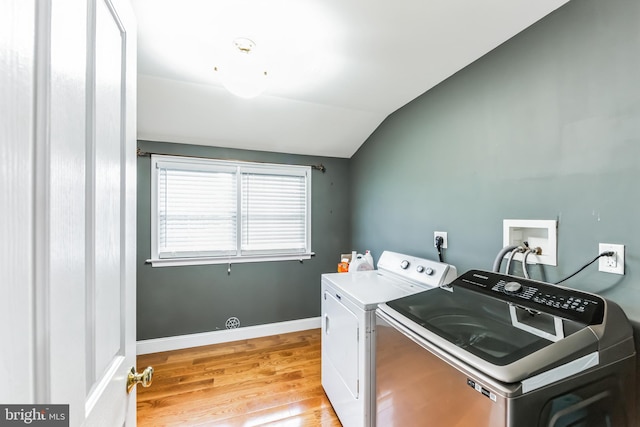 laundry room with independent washer and dryer and light hardwood / wood-style floors