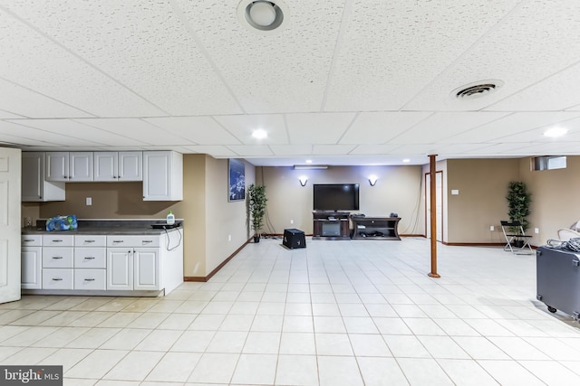 interior space featuring a drop ceiling and light tile patterned flooring