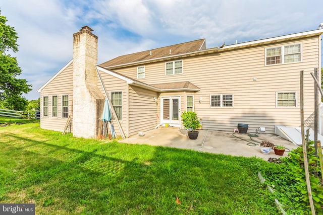 rear view of property featuring a yard and a patio area