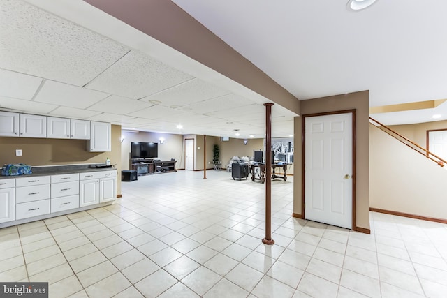 interior space with a drop ceiling and light tile patterned floors