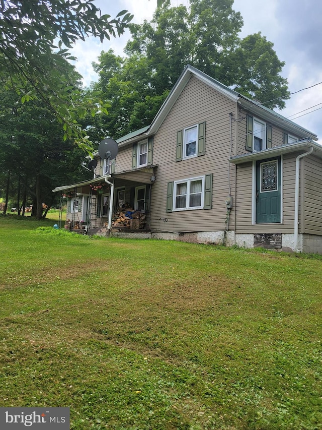 back of property featuring a yard and a porch