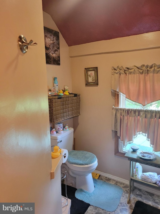 bathroom featuring tile patterned floors, toilet, and vaulted ceiling