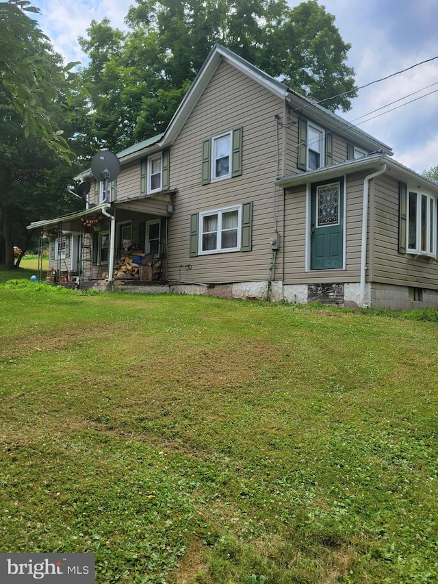 rear view of house featuring a lawn