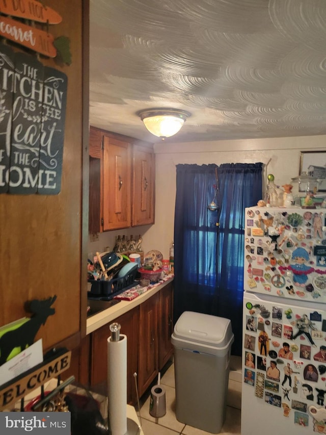 kitchen featuring light tile patterned floors and white fridge