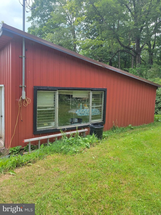 view of side of property featuring an outbuilding and a lawn