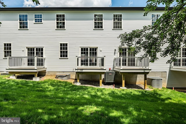 back of property featuring a lawn and central AC