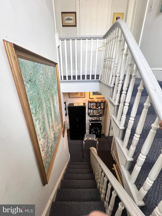 stairway featuring carpet and a high ceiling