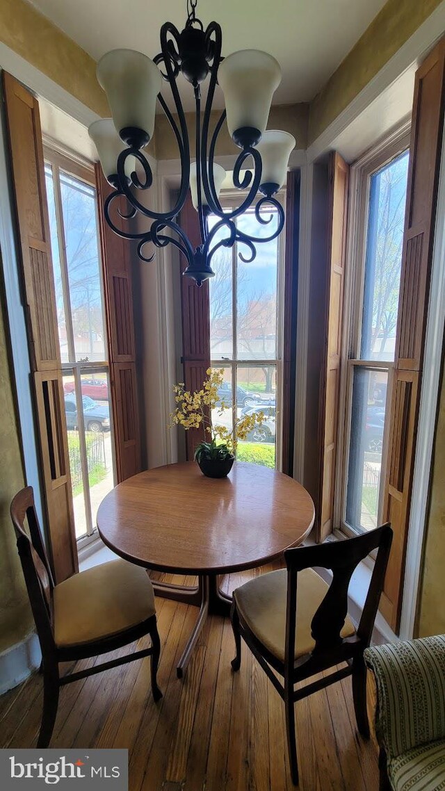 dining room with hardwood / wood-style flooring and an inviting chandelier