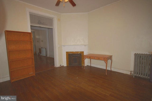 unfurnished living room with ceiling fan, radiator, crown molding, and dark hardwood / wood-style floors