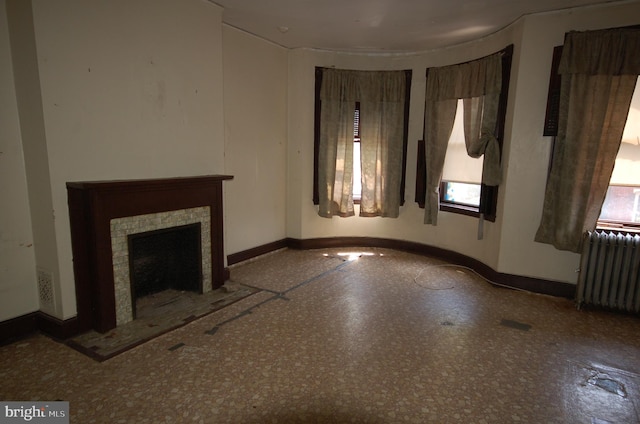 unfurnished living room featuring radiator and a tile fireplace