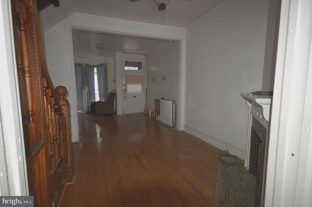 interior space featuring ceiling fan, radiator, hardwood / wood-style floors, and a fireplace