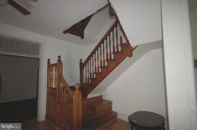 stairway with wood-type flooring and ceiling fan