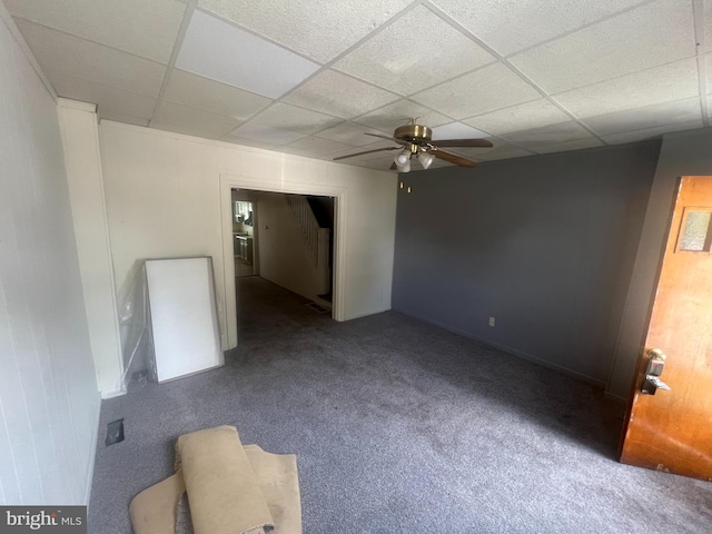 carpeted empty room with a paneled ceiling and ceiling fan