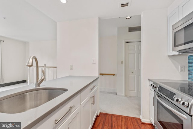 kitchen with white cabinets, dark wood-type flooring, sink, and stainless steel appliances