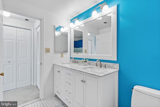 bathroom with tile patterned flooring, vanity, and toilet