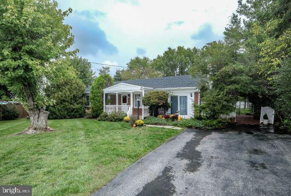 ranch-style home featuring a front lawn and a porch