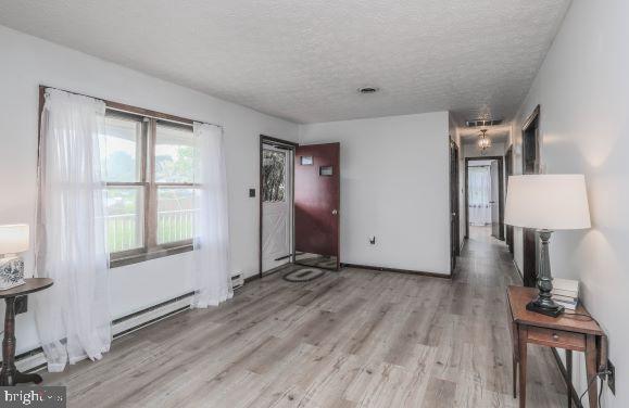 entrance foyer with a textured ceiling and light hardwood / wood-style flooring