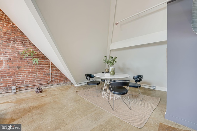 dining space featuring brick wall