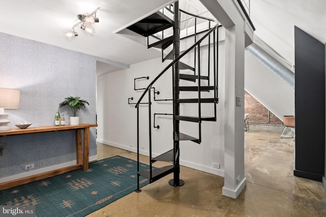 interior space featuring an accent wall, baseboards, and concrete flooring