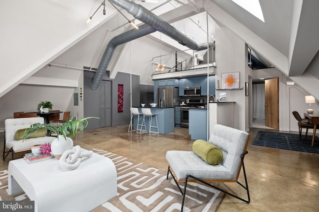 living room featuring finished concrete floors, a skylight, a high ceiling, and an inviting chandelier