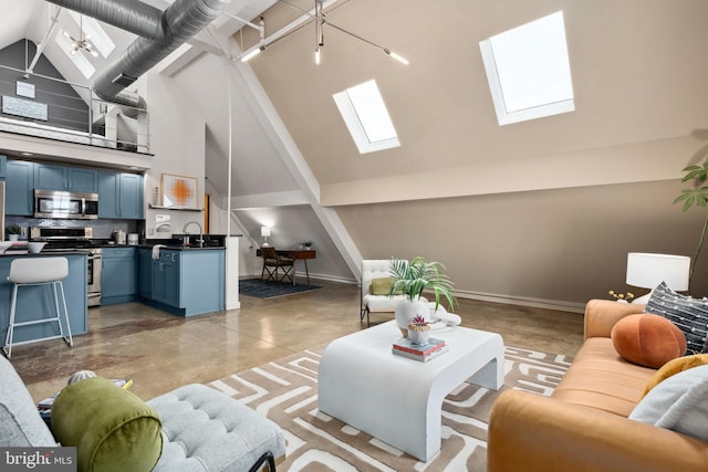 living room with finished concrete flooring, a skylight, baseboards, and high vaulted ceiling