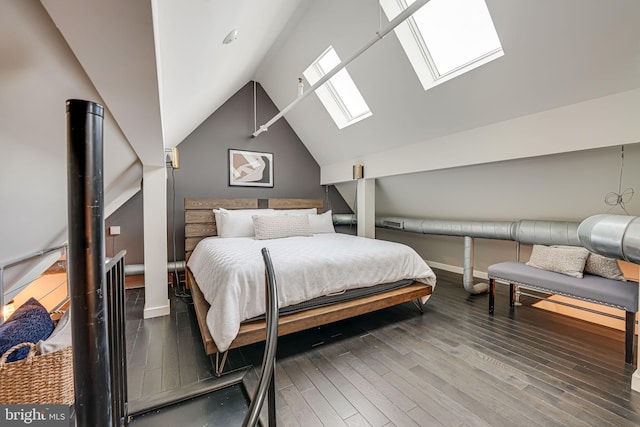 bedroom featuring vaulted ceiling with skylight and hardwood / wood-style flooring