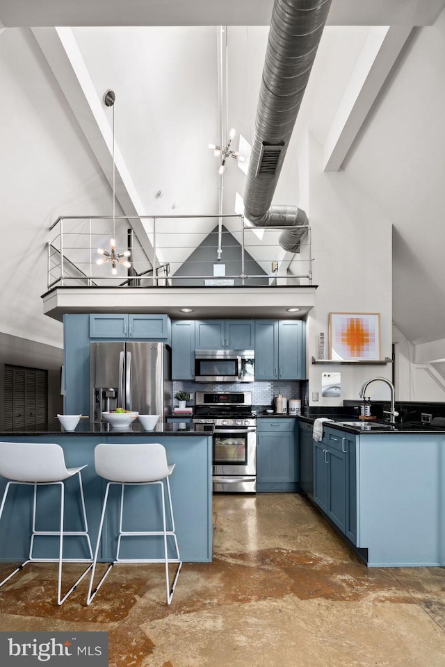 kitchen featuring stainless steel appliances, dark countertops, high vaulted ceiling, and blue cabinetry