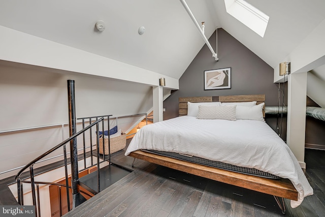 bedroom with vaulted ceiling with skylight and dark hardwood / wood-style flooring