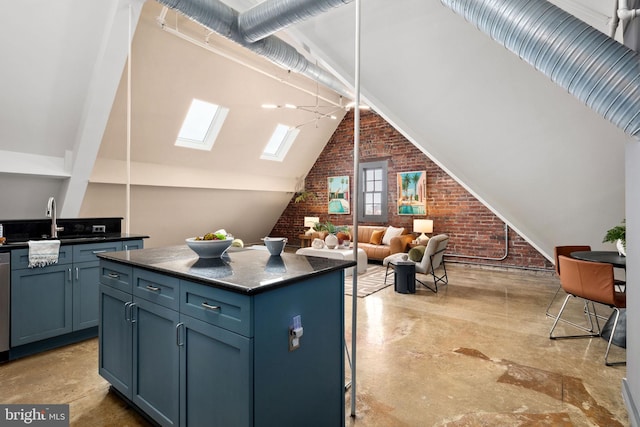 kitchen featuring dark countertops, vaulted ceiling with skylight, brick wall, and a kitchen island