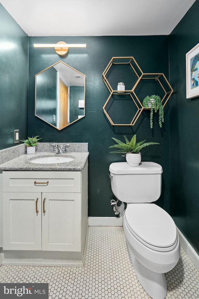 bathroom featuring toilet, vanity, baseboards, and tile patterned floors