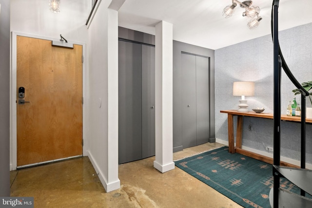 foyer featuring baseboards and finished concrete floors