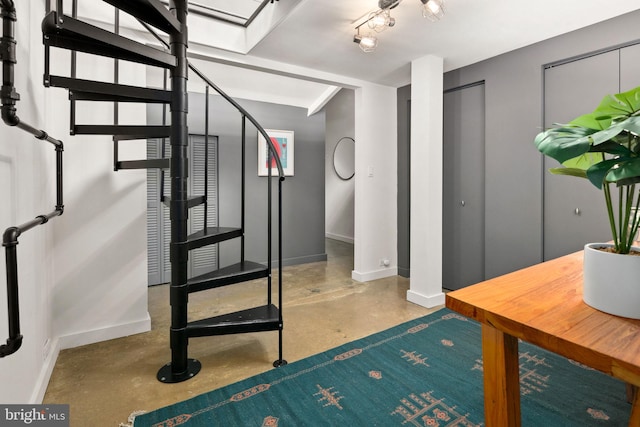 foyer entrance featuring finished concrete flooring and baseboards