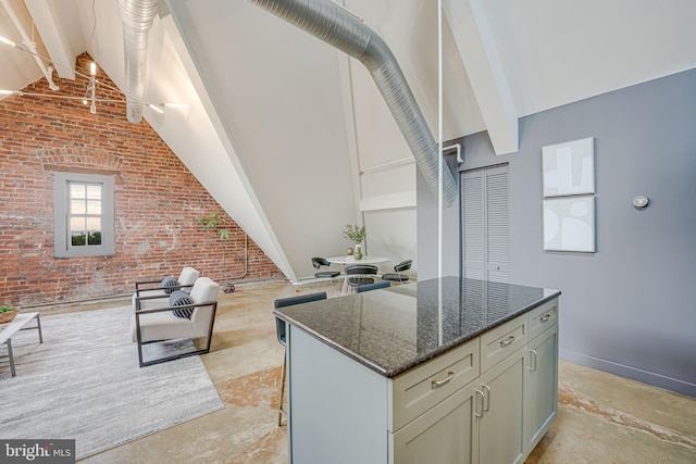 kitchen with dark stone counters, beam ceiling, brick wall, and high vaulted ceiling