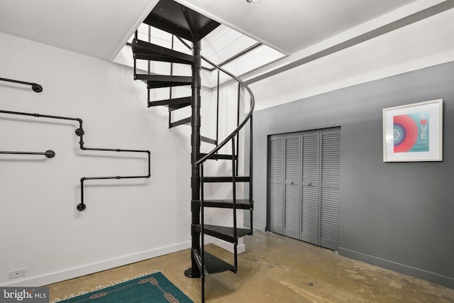 stairway with concrete flooring and baseboards