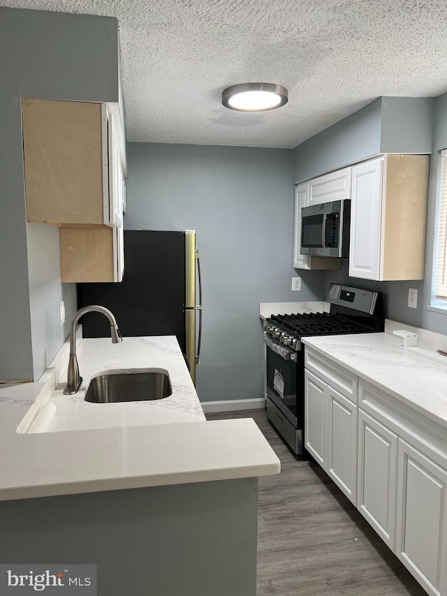 kitchen featuring white cabinets, appliances with stainless steel finishes, and sink