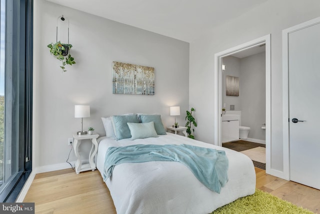 bedroom with light hardwood / wood-style flooring and ensuite bathroom