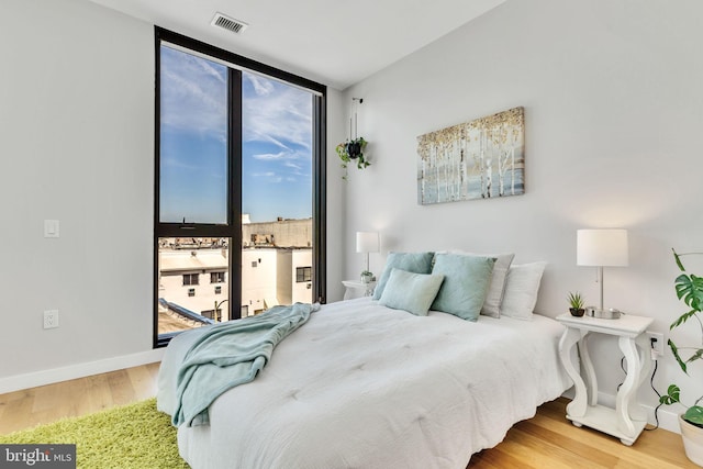 57 N St NW Unit 433, Washington, DC 20001 - bedroom featuring a wall of windows, wood finished floors, visible vents, and baseboards