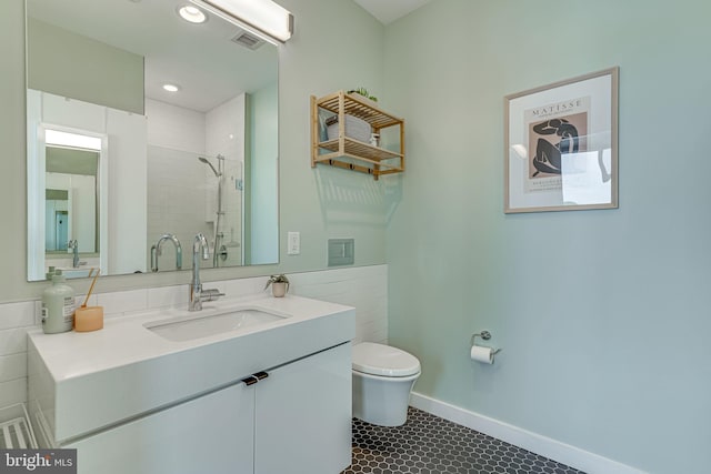 bathroom featuring vanity, toilet, tile patterned floors, and a tile shower