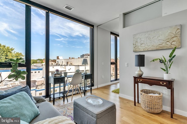 57 N St NW Unit 433, Washington, DC 20001 - living room featuring a wall of windows, visible vents, baseboards, and wood finished floors