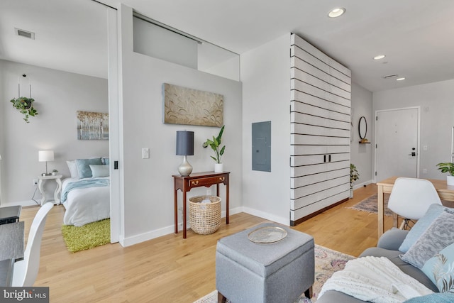 living room featuring electric panel and light hardwood / wood-style flooring