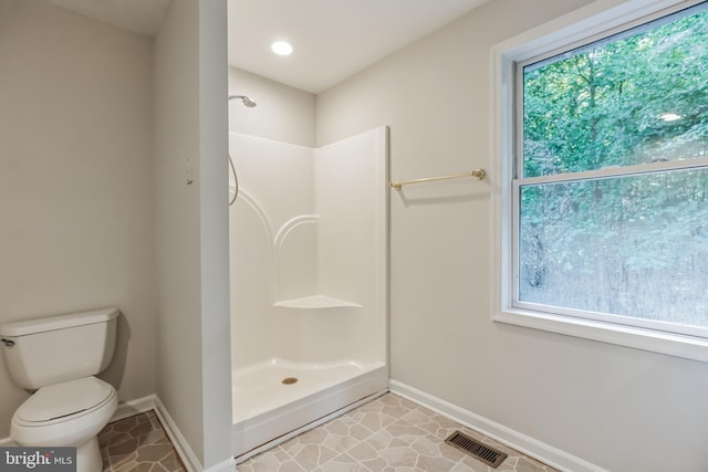 bathroom with toilet, a wealth of natural light, and a shower