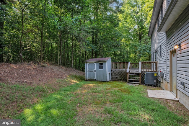 view of yard with a deck, a shed, and cooling unit