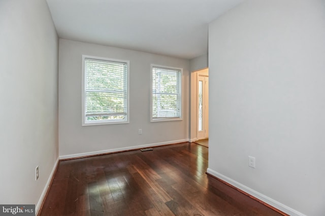 unfurnished room with dark hardwood / wood-style flooring