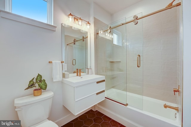 full bathroom with tile patterned floors, vanity, bath / shower combo with glass door, and toilet