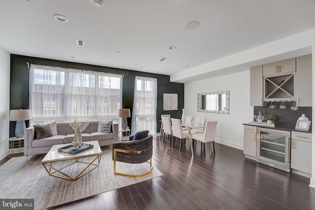 living room featuring bar, dark hardwood / wood-style flooring, and beverage cooler