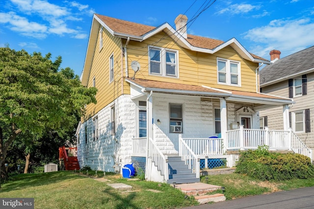 view of front facade featuring covered porch and a front yard