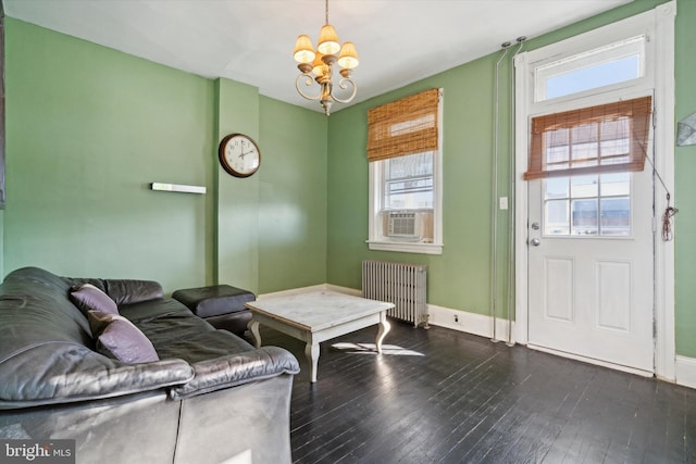 living room featuring a notable chandelier, dark hardwood / wood-style flooring, radiator heating unit, and plenty of natural light