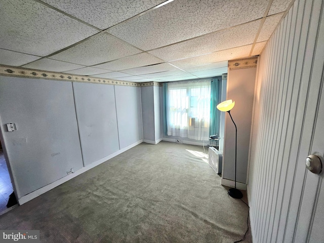 basement with a paneled ceiling and carpet floors