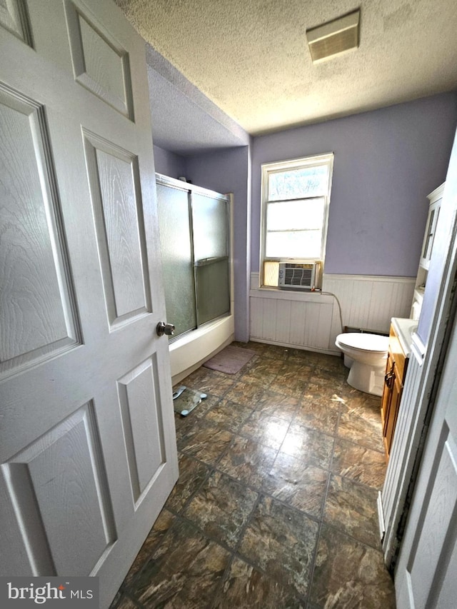 bathroom with vanity, cooling unit, toilet, and a textured ceiling