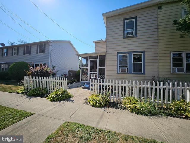 view of front facade featuring cooling unit and a sunroom